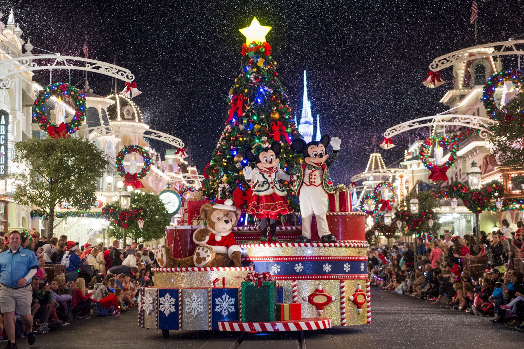 Mickey Mouse, Minnie Mouse and Duffy wave to Magic Kingdom guests as snow falls on Main Street, U.S.A., during " Mickey's Once Upon a Christmastime Parade" at Walt Disney World Resort. The festive processional is one of the happy highlights of Mickey's Very Merry Christmas Party, a night of holiday splendor with lively stage shows, a unique holiday parade, Holiday Wishes: Celebrate the Spirit of the Season nighttime fireworks, and snow flurries on Main Street, U.S.A. The special-ticket event takes place on select nights in November and December at Magic Kingdom in Lake Buena Vista, Fla. (Ryan Wendler, photographer)